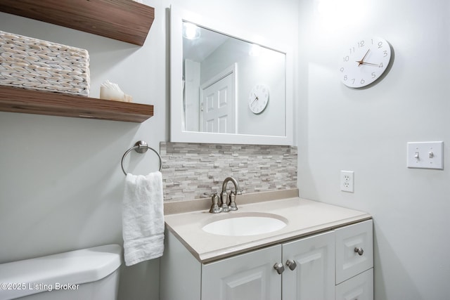 half bath featuring tasteful backsplash, toilet, and vanity