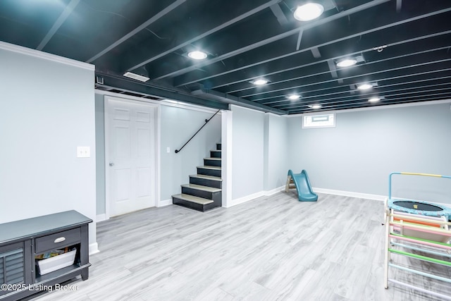below grade area with stairway, wood finished floors, and baseboards