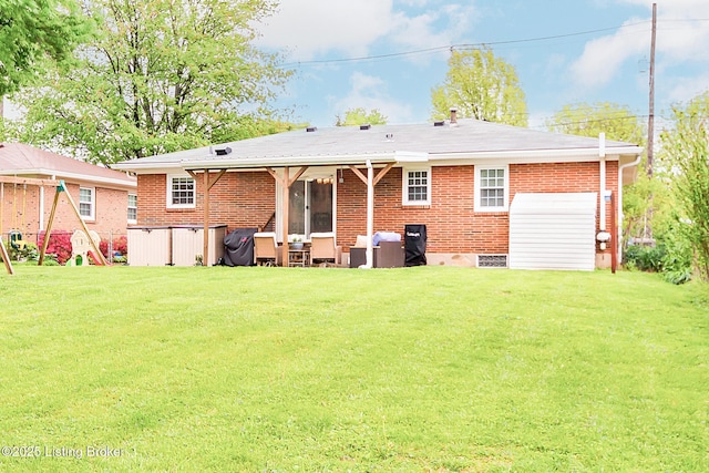 rear view of house with brick siding and a lawn