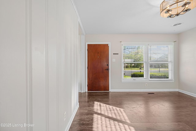 entryway featuring an inviting chandelier, visible vents, wood finished floors, and baseboards