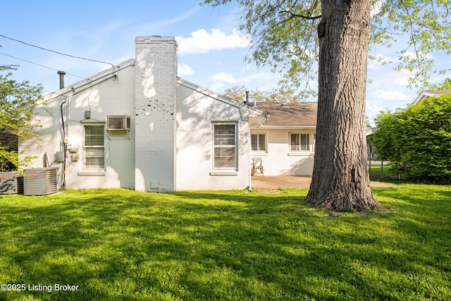 rear view of property featuring a patio area, a chimney, cooling unit, and a yard