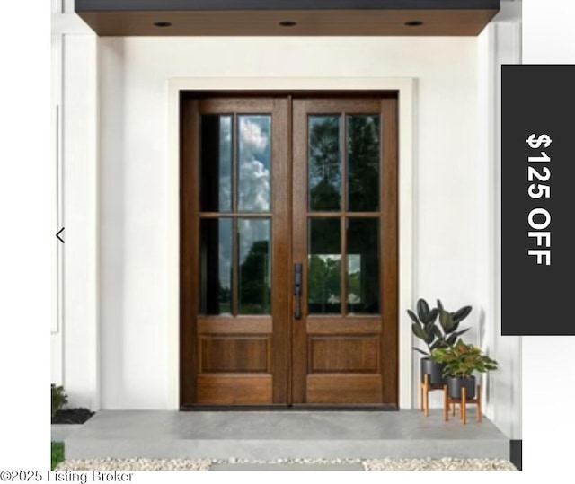 view of exterior entry with french doors and stucco siding