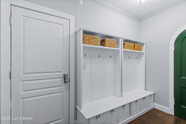 mudroom with arched walkways, baseboards, and dark wood-style floors