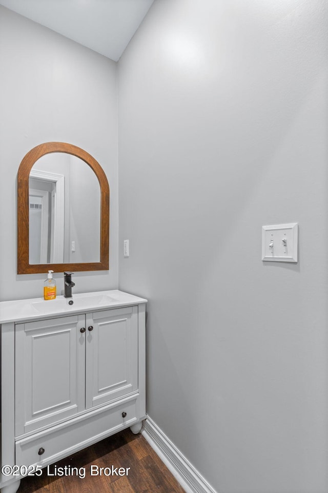 bathroom featuring baseboards, vanity, and wood finished floors