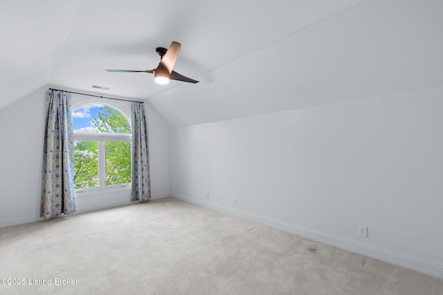 additional living space with carpet flooring, ceiling fan, baseboards, vaulted ceiling, and visible vents