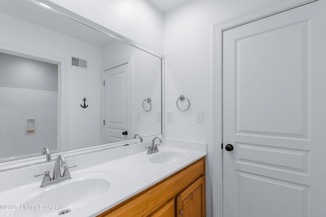 bathroom with double vanity, visible vents, and a sink