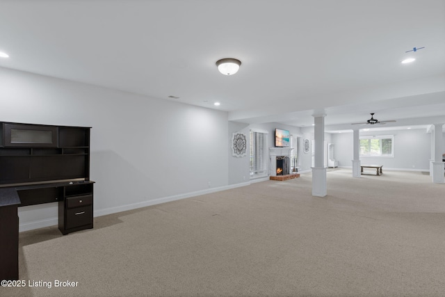 below grade area with baseboards, a brick fireplace, and carpet flooring