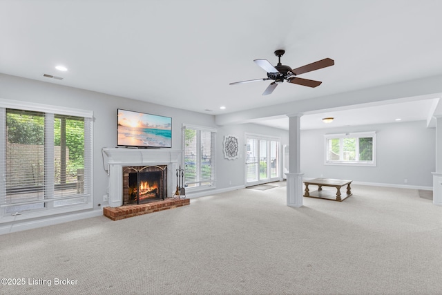 unfurnished living room with ceiling fan, light carpet, a brick fireplace, baseboards, and visible vents