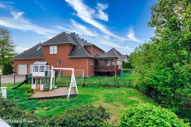 rear view of property with roof with shingles, a lawn, brick siding, a fenced backyard, and a playground