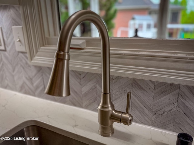 details featuring light stone counters and a sink