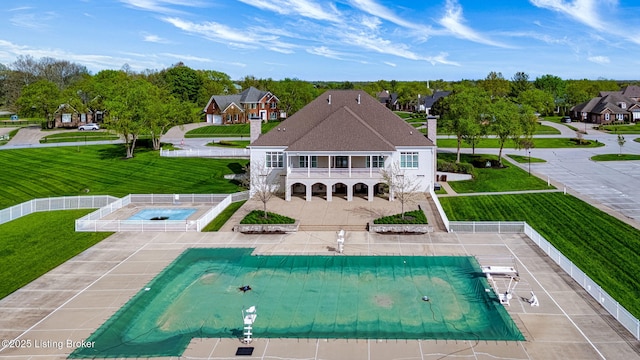 view of swimming pool with fence, a patio, a covered pool, a lawn, and an in ground hot tub
