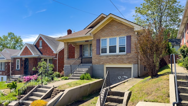 bungalow with stairway, brick siding, a chimney, and a garage