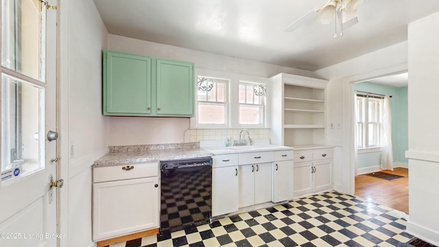 kitchen with open shelves, dishwasher, light countertops, a sink, and light floors