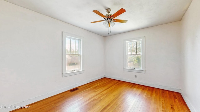 unfurnished room featuring baseboards, visible vents, and a healthy amount of sunlight