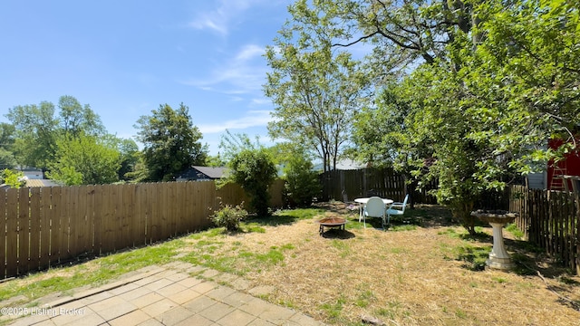 view of yard featuring a patio, a fire pit, and a fenced backyard