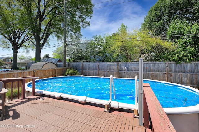 view of swimming pool featuring a wooden deck, a fenced in pool, and a fenced backyard