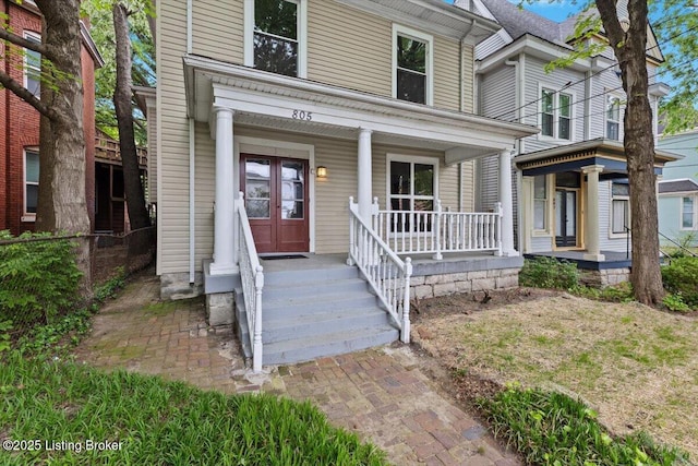 doorway to property with fence and a porch