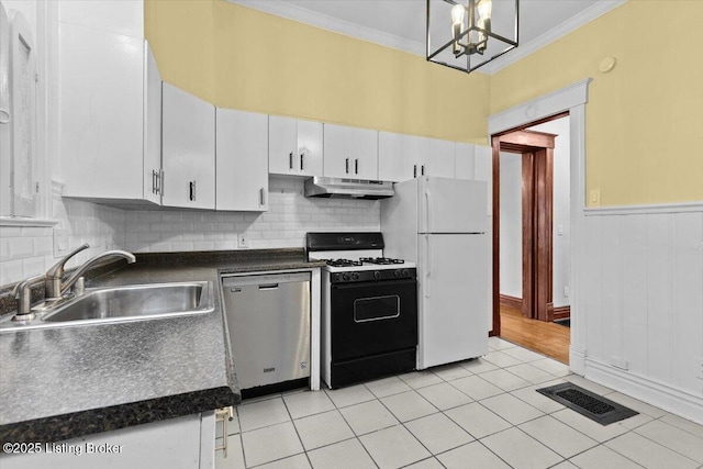 kitchen featuring stainless steel dishwasher, dark countertops, visible vents, gas range, and under cabinet range hood