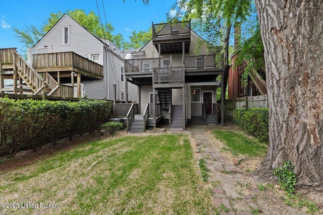 back of house featuring a lawn, fence, stairs, and a wooden deck