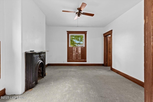 unfurnished living room with baseboards, a ceiling fan, and carpet flooring