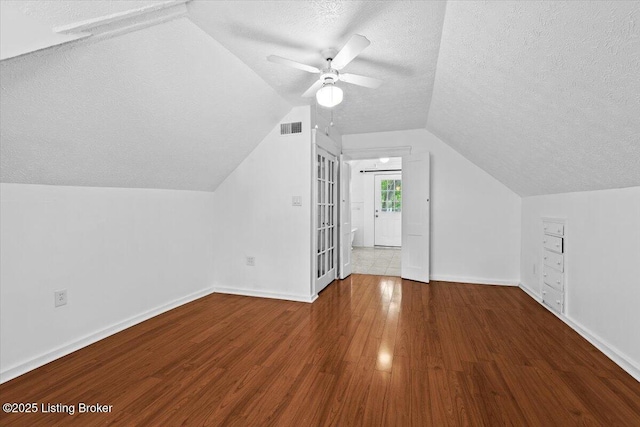 bonus room featuring visible vents, wood finished floors, a ceiling fan, and a textured ceiling