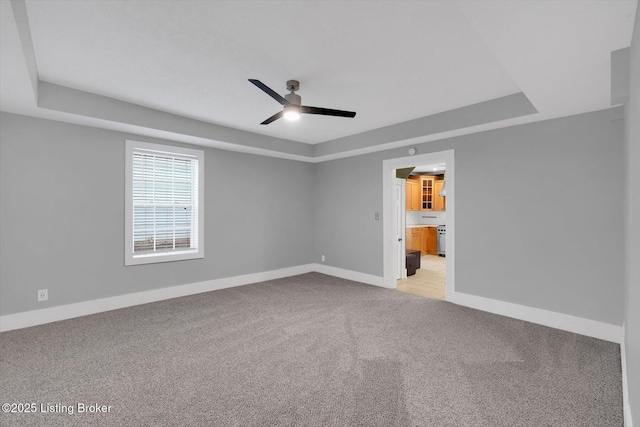 206 E Madison St, La Grange, KY 40031 - spare room with a ceiling fan, light colored carpet, a tray ceiling, and baseboards