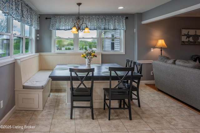 dining room with light tile patterned floors, breakfast area, and a notable chandelier