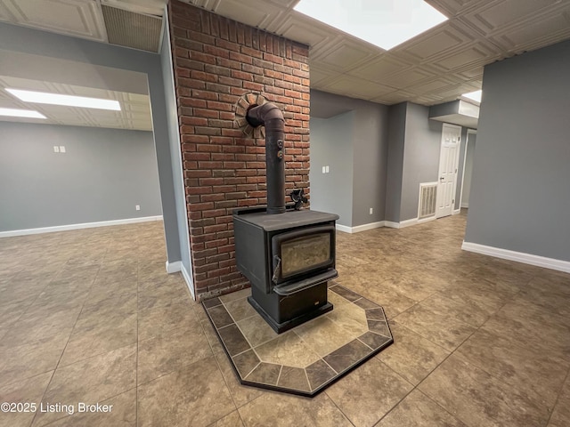 interior space with a wood stove, visible vents, and baseboards