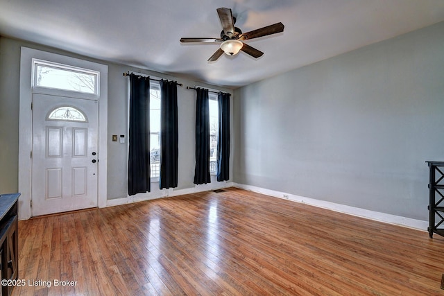 entryway featuring wood finished floors, a ceiling fan, visible vents, and baseboards