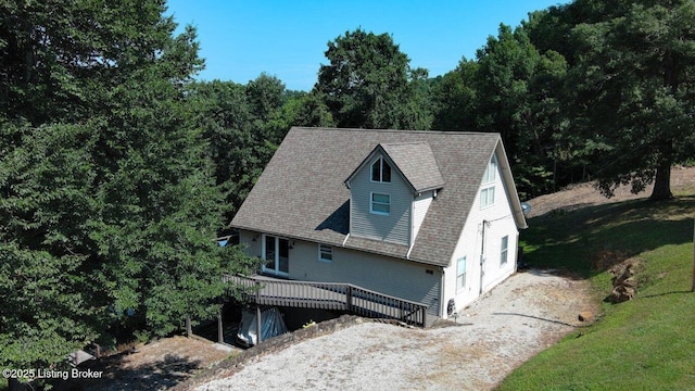 view of front facade featuring a wooden deck and a shingled roof