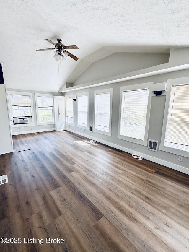 unfurnished living room with lofted ceiling, a textured ceiling, ceiling fan, visible vents, and wood finished floors
