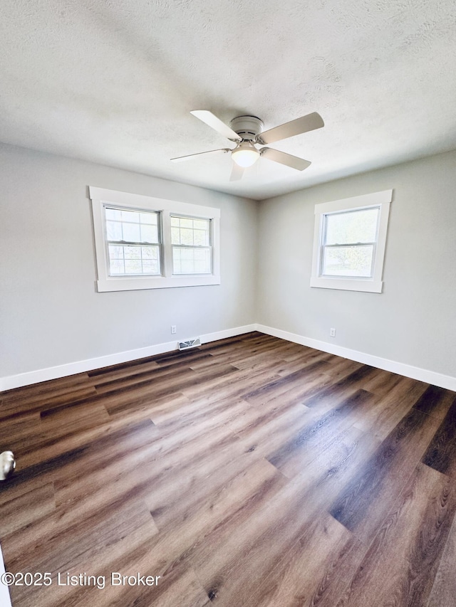 spare room with a wealth of natural light, a ceiling fan, and baseboards