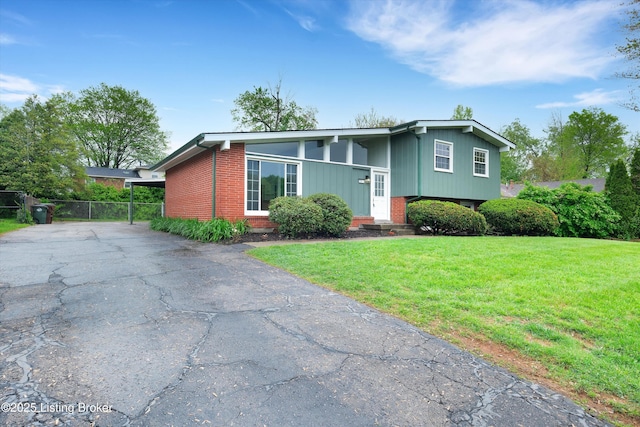 2311 Langdon Dr, Louisville, KY 40242 - view of front of home with fence, brick siding, aphalt driveway, and a front lawn