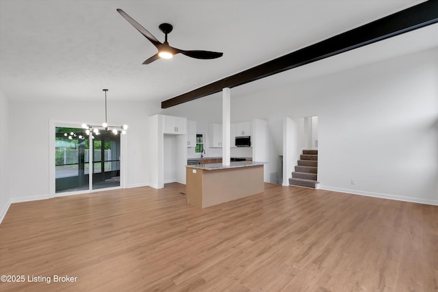 2311 Langdon Dr, Louisville, KY 40242 - unfurnished living room with baseboards, light wood-type flooring, and ceiling fan with notable chandelier