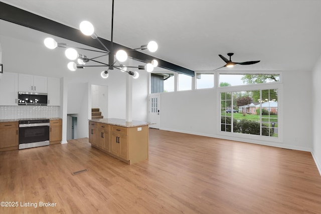 2311 Langdon Dr, Louisville, KY 40242 - kitchen featuring stainless steel microwave, decorative backsplash, vaulted ceiling with beams, range with electric stovetop, and ceiling fan with notable chandelier