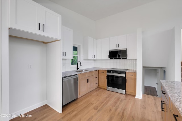 2311 Langdon Dr, Louisville, KY 40242 - kitchen with range with electric cooktop, light stone counters, stainless steel dishwasher, a sink, and light wood-type flooring