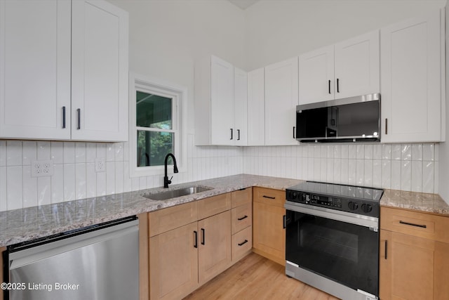 2311 Langdon Dr, Louisville, KY 40242 - kitchen with stainless steel dishwasher, light stone counters, black electric range, backsplash, and a sink