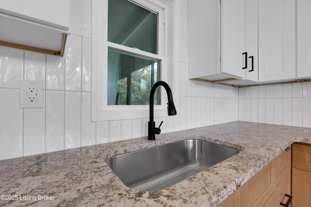2311 Langdon Dr, Louisville, KY 40242 - kitchen with light stone countertops, a sink, backsplash, and white cabinetry