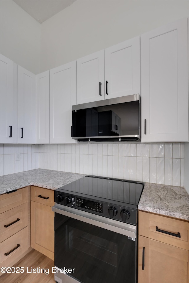 2311 Langdon Dr, Louisville, KY 40242 - kitchen featuring stainless steel microwave, electric stove, light stone countertops, and backsplash