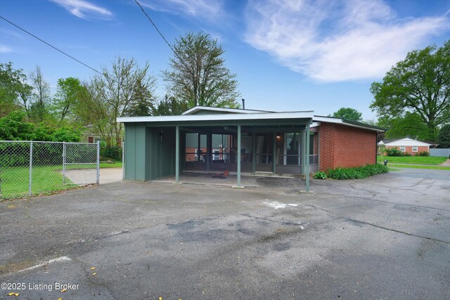 2311 Langdon Dr, Louisville, KY 40242 - exterior space featuring fence, a carport, driveway, and brick siding