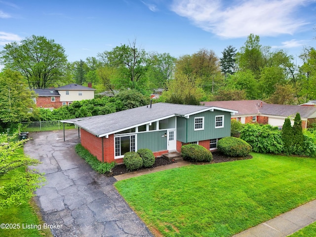 2311 Langdon Dr, Louisville, KY 40242 - view of front of house featuring driveway, a carport, a front yard, fence, and brick siding