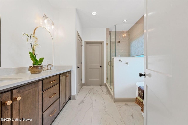 bathroom with double vanity, a sink, marble finish floor, and a stall shower