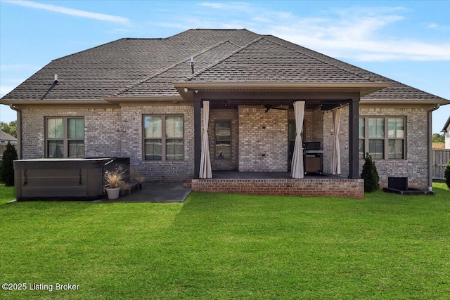 rear view of house featuring a patio, a shingled roof, and a hot tub
