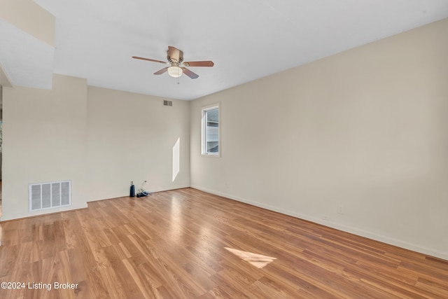 spare room with a ceiling fan, baseboards, visible vents, and light wood finished floors