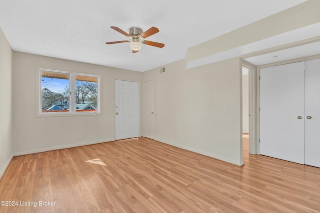 unfurnished room featuring baseboards, a ceiling fan, light wood-style flooring, and visible vents