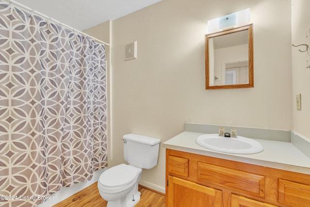 full bath featuring toilet, visible vents, wood finished floors, and vanity
