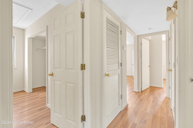 corridor featuring baseboards and light wood-style floors