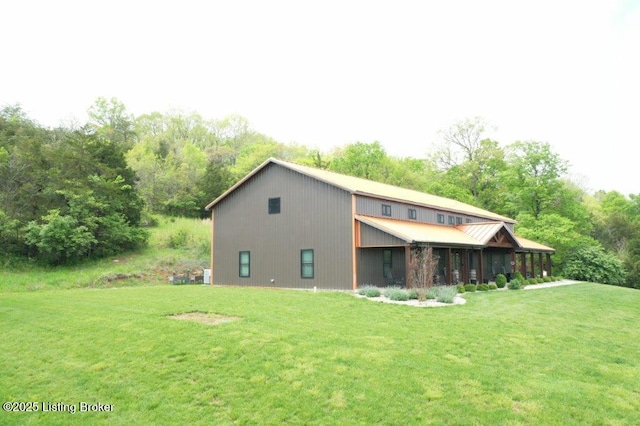back of house featuring metal roof and a lawn