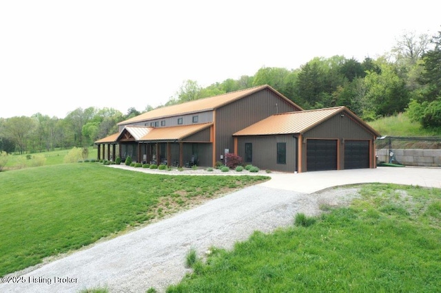 view of front of home featuring a standing seam roof, metal roof, a front lawn, and a garage