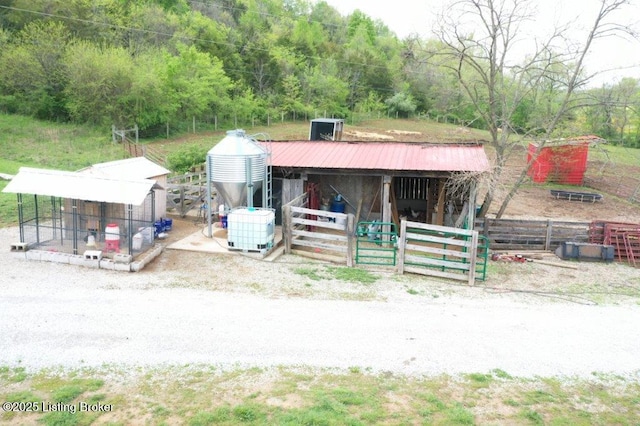 view of horse barn with a wooded view